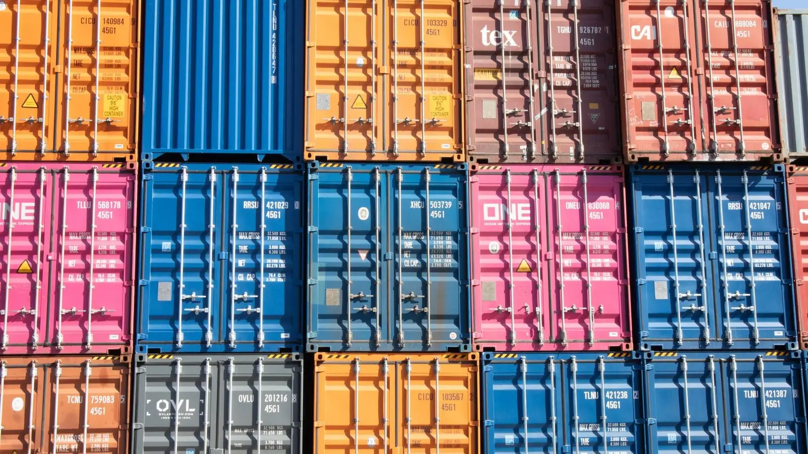 Multicoloured shipping containers stacked in a port storage area