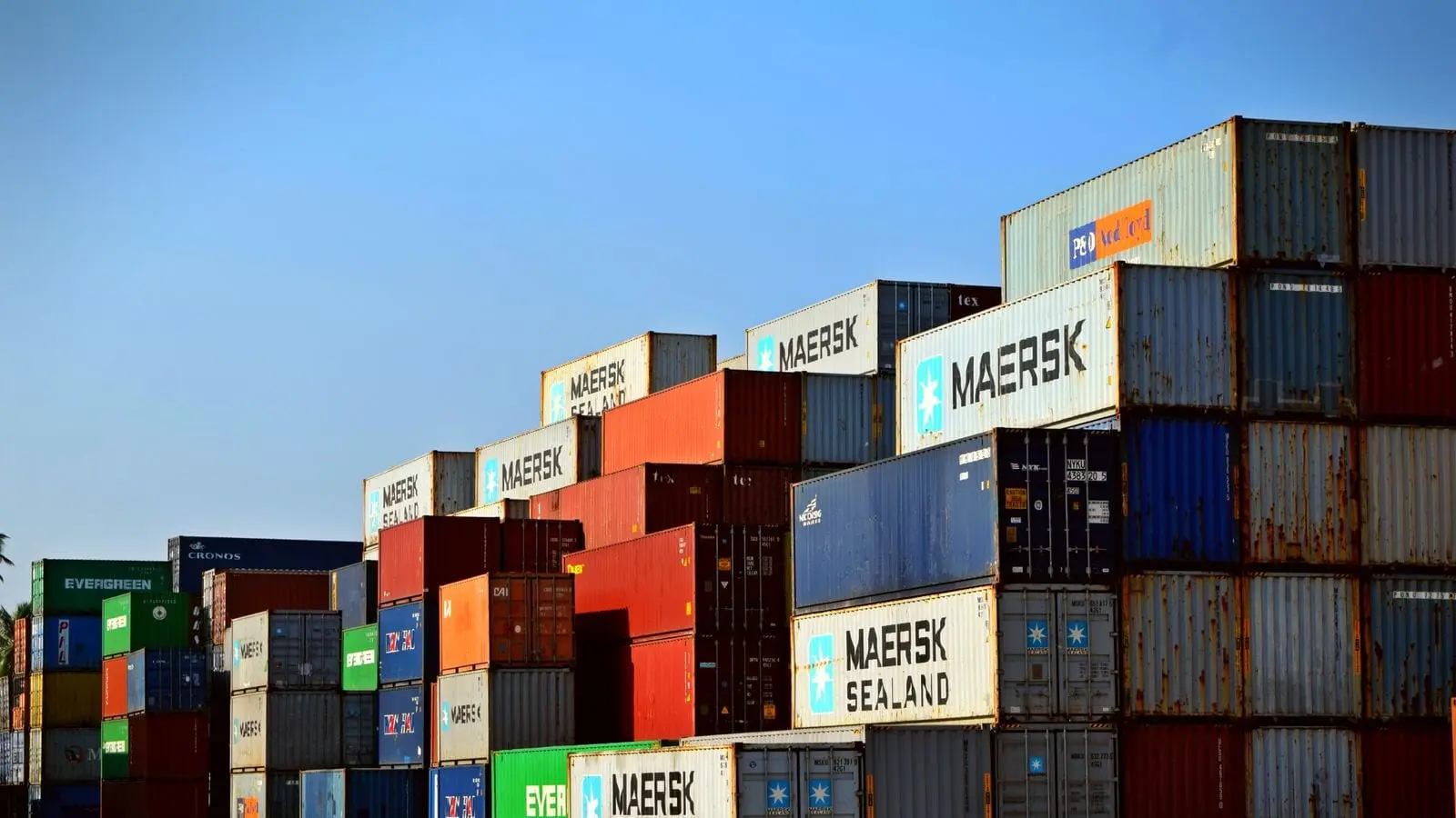 Rows of stacked shipping containers filling a terminal storage yard