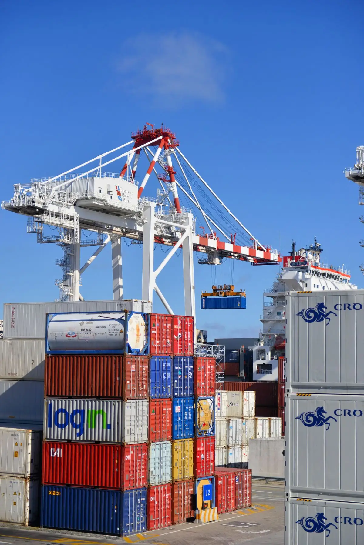 Colorful shipping containers stacked at a busy container port